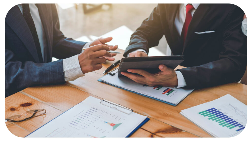 Businessman using tablet while discussing marketing in the meeting.