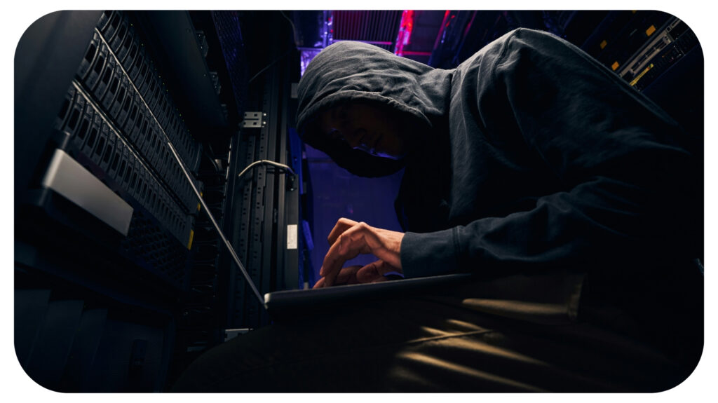 hacker installing malicious software on data center servers using laptop.