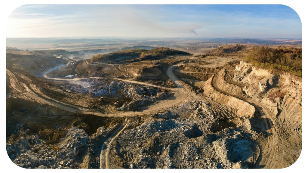 Aerial view of open pit mine of sandstone materials for construction industry with excavators and dump trucks.