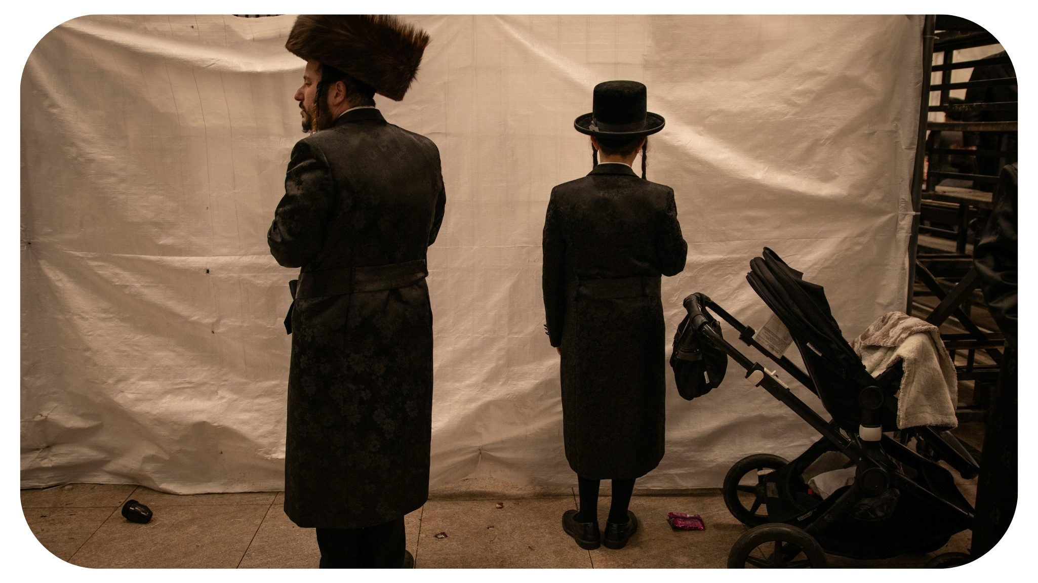 a couple of men standing next to a baby carriage.