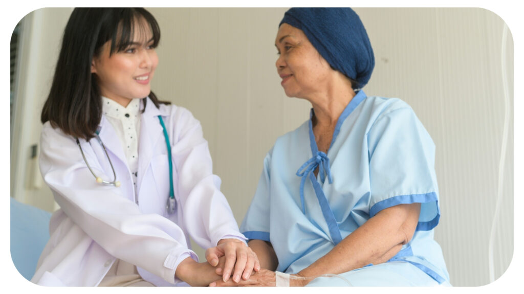 Doctor holding senior cancer patient's hand in hospital.