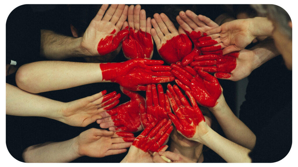 hands formed together with red heart paint.