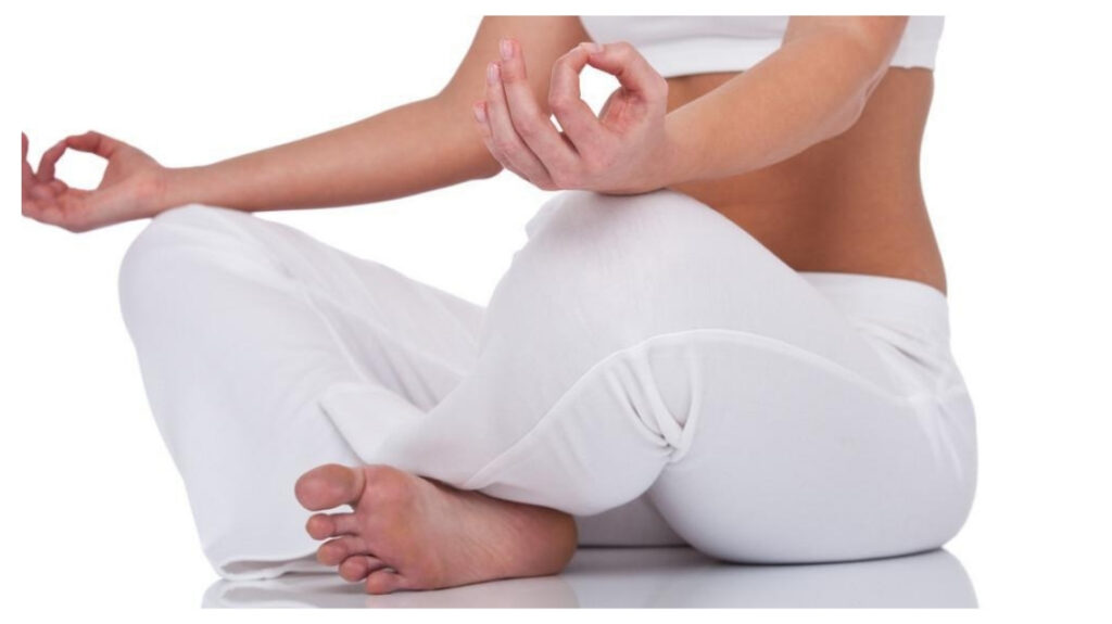 Women doing meditation in white dress.