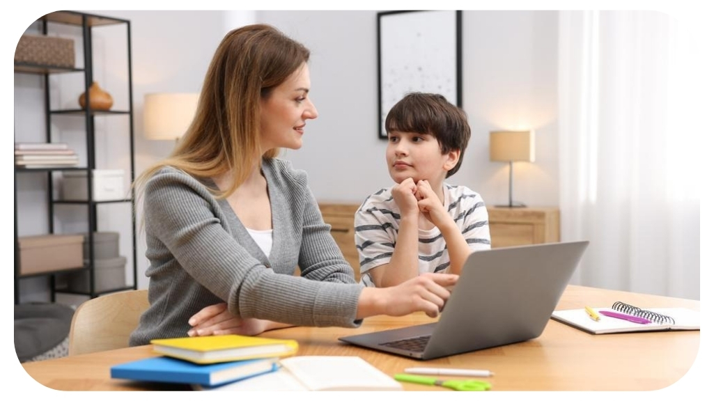 Mother and son working together at a laptop during a homeschooling session in a modern living room.