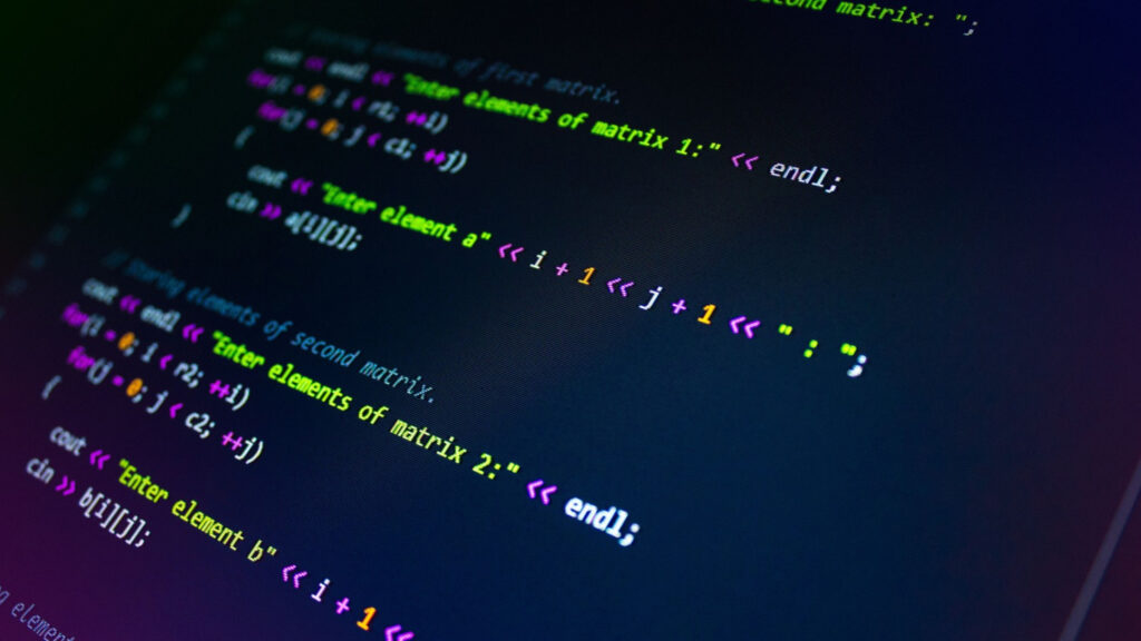 Close-up of colorful programming code displayed on a dark computer screen, showing C++ code for working with matrices.